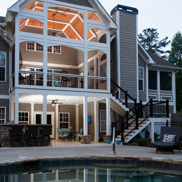 exterior of large screened in patio and stairs leading to lower deck and pool