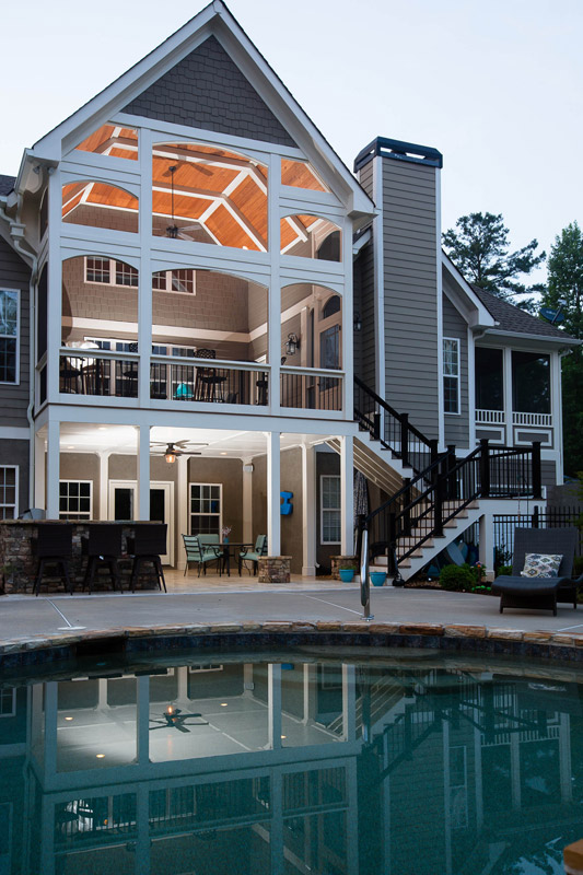 exterior of large screened in patio and stairs leading to lower deck and pool